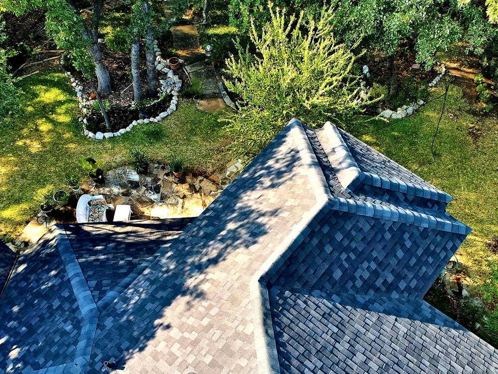 Straight-down drone view of a complete hip roof surrounded by trees