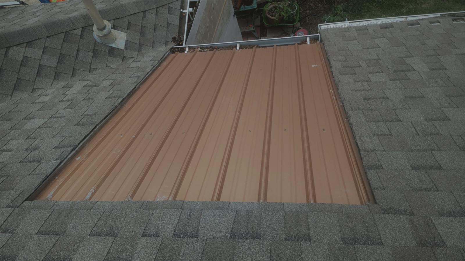 Before: mismatched metal panel patched into a shingle roof
