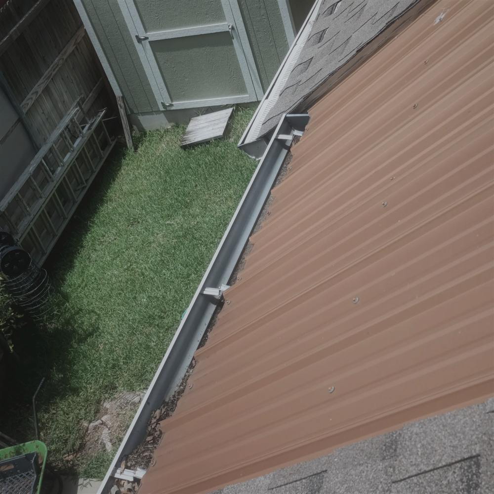 Before: metal panel edge with debris-filled gutter at the patio