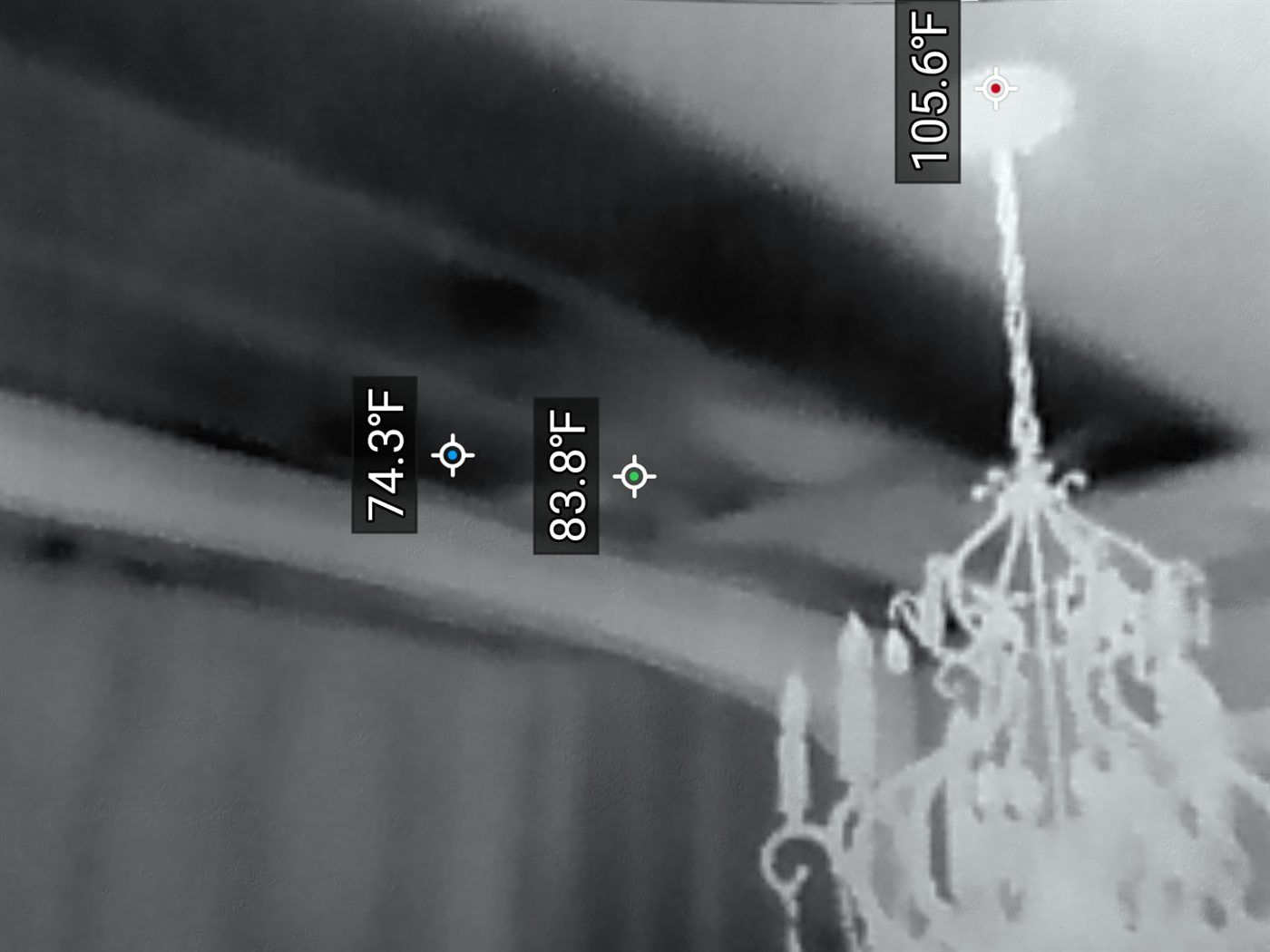 Infrared image above a ceiling showing moisture tracking along framing near a chandelier