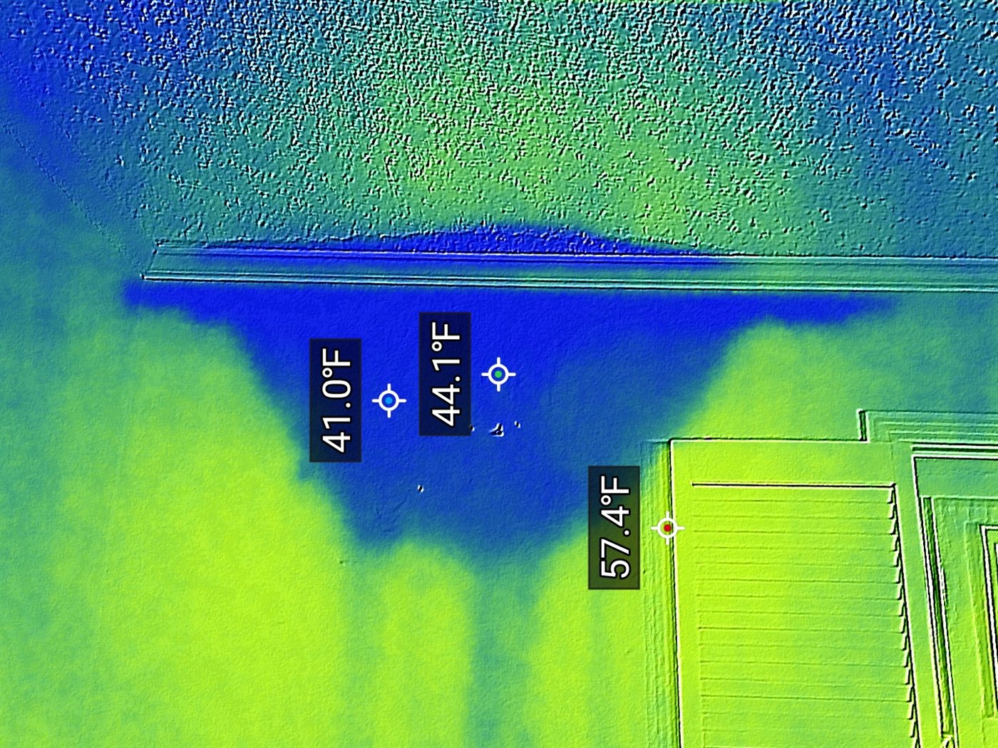 Thermal image: cold anomaly from hidden moisture inside a wall, 41°F against a 57°F wall